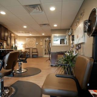 A cozy and modern hair salon interior featuring a waiting area and styling chairs.