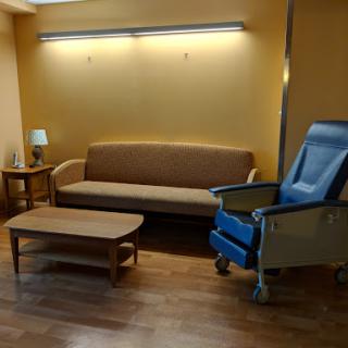 A cozy waiting area featuring a sofa, a chair, and a table.
