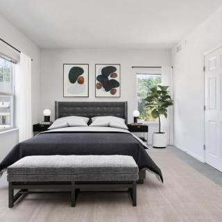 A modern, minimalist bedroom with a neatly made bed and stylish decor.