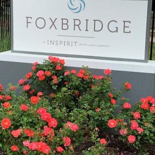 A sign reading 'Foxbridge' surrounded by blooming red roses.