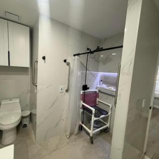 A modern bathroom featuring essential amenities and a medical equipment setup.
