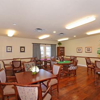 An interior view of a dining room with multiple tables and chairs, decorated with wall art and bright lighting.