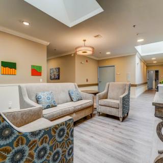 A modern and bright lobby area with comfortable seating and artwork on the walls.