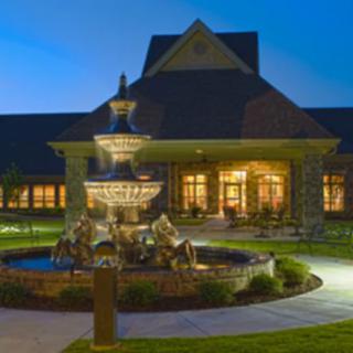 A beautifully lit building at night featuring a prominent fountain in the foreground.