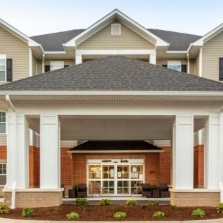 A residential building with a covered entrance and large columns.