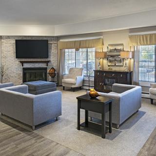 A modern living room with comfortable seating and a fireplace, featuring a television and stylish decor.
