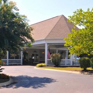 Front view of a building with a landscaped entrance and driveway.