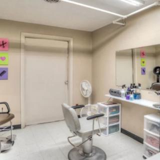 A tidy hair salon with a styling chair, mirror, and organized beauty products.