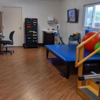 A physical therapy room equipped with various rehabilitation and exercise equipment.