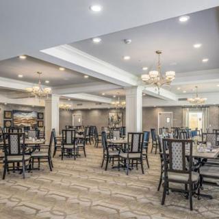 An elegant dining area with neatly arranged tables and chairs, featuring sophisticated lighting fixtures.