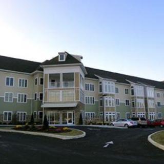 A three-story residential building with a well-maintained exterior and landscaped surroundings.