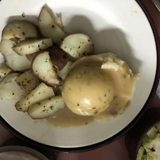 A plate of sliced potatoes with gravy.