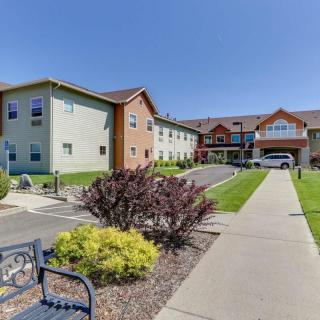 A sunny day view of a residential building with landscaped gardens and pathways.