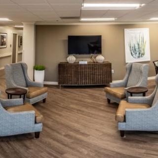 A modern seating area with comfortable chairs and a television in the lobby.