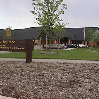 A park entrance with a building and sign visible in a landscaped area.