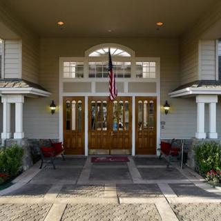 The main entrance of a building featuring wooden doors, columns, and an American flag.