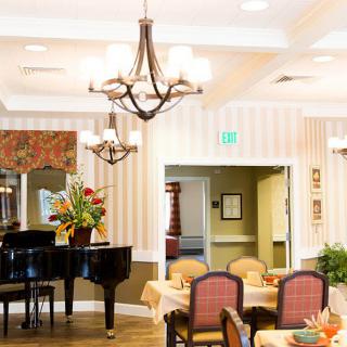 A well-decorated dining area featuring a grand piano and elegant chandeliers.