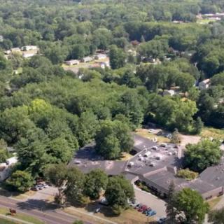 Aerial view of a suburban area with dense trees and buildings.