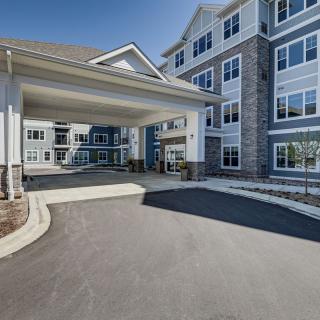 A modern building with a covered entrance and driveway.