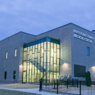 Proton Therapy Medical Center at dusk, showcasing modern architecture and well-lit entrance.