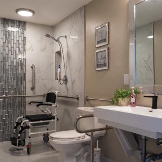A modern, accessible bathroom featuring a wheelchair-accessible shower and essential safety features.