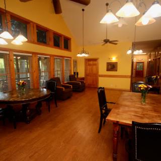 A spacious and well-lit dining area featuring wooden furniture and large windows.