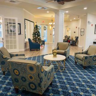 A cozy lobby seating area with patterned chairs and a table, featuring a decorative carpet and festive decorations.