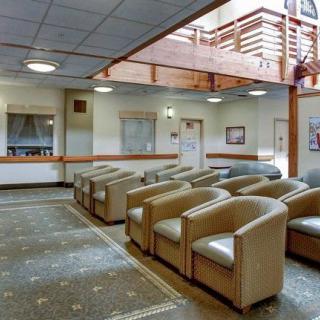 A spacious waiting room with rows of comfortable chairs and a bright, open layout.