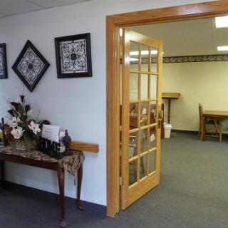 A view of an office interior with a wooden door, decorative items, and artwork on the wall.