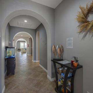 A modern hallway featuring arched doorways and neutral decor.