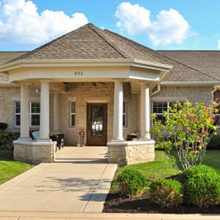 A welcoming front entrance to a residential building, showcasing beautiful landscaping.