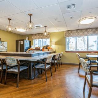 A well-lit dining area featuring a central table with chairs and modern lighting.