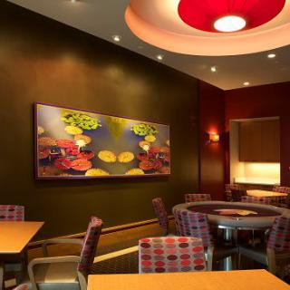 A modern restaurant interior featuring stylish seating and contemporary art on the walls.