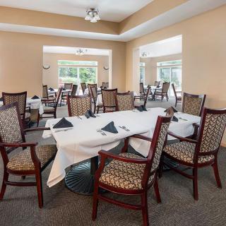 A spacious and elegant dining area with neatly arranged tables and chairs, ready for guests.