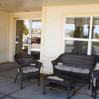 Outdoor patio area with wicker seating and a small table.