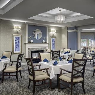A beautifully arranged dining area featuring elegant tables and chairs, complemented by soft lighting and tasteful decor.