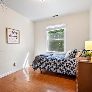 A cozy and bright bedroom featuring plaid bedding and natural light filtering through the window.