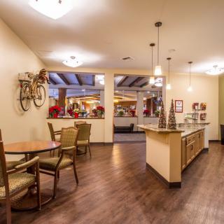 A cozy cafe interior with bicycle-themed decor, featuring tables, chairs, and warm lighting.
