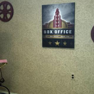 A movie-themed wall decorated with a 'Box Office' poster and film reels.