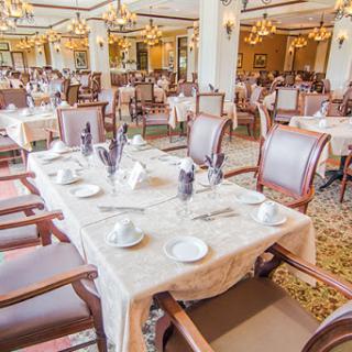 An elegant dining area featuring beautifully arranged tables and chairs, perfect for a sophisticated meal.