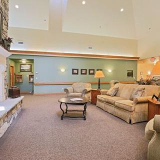 A cozy living room with comfortable sofas, a central coffee table, and a fireplace.