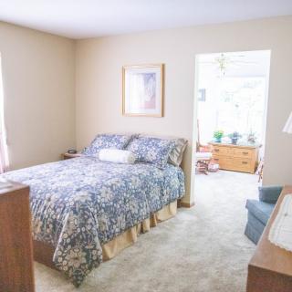 Cozy bedroom with a patterned bedspread and natural lighting.