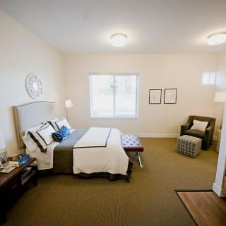 A cozy and modern bedroom featuring elegant furniture and warm lighting.