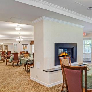 A cozy dining area featuring a central fireplace and elegant seating arrangement.