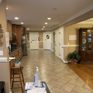 A spacious kitchen and dining area featuring a wooden cabinet, tile flooring, and modern lighting.