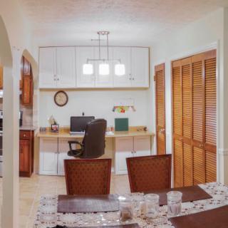 A cozy home office setup with a desk, computer, and comfortable chair.