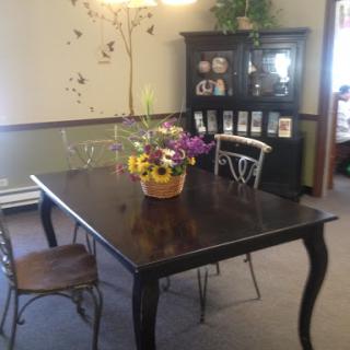 A cozy dining room setup featuring a dark wooden table adorned with a vibrant flower arrangement.