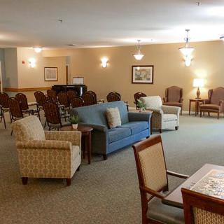 A cozy, well-furnished living room with sofas, chairs, and ambient lighting.
