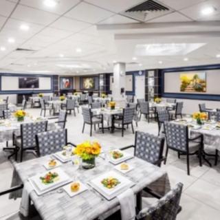 A spacious and elegantly arranged dining area with neatly set tables and chairs.