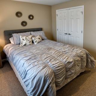 A cozy bedroom with a neatly made bed and decorative pillows.